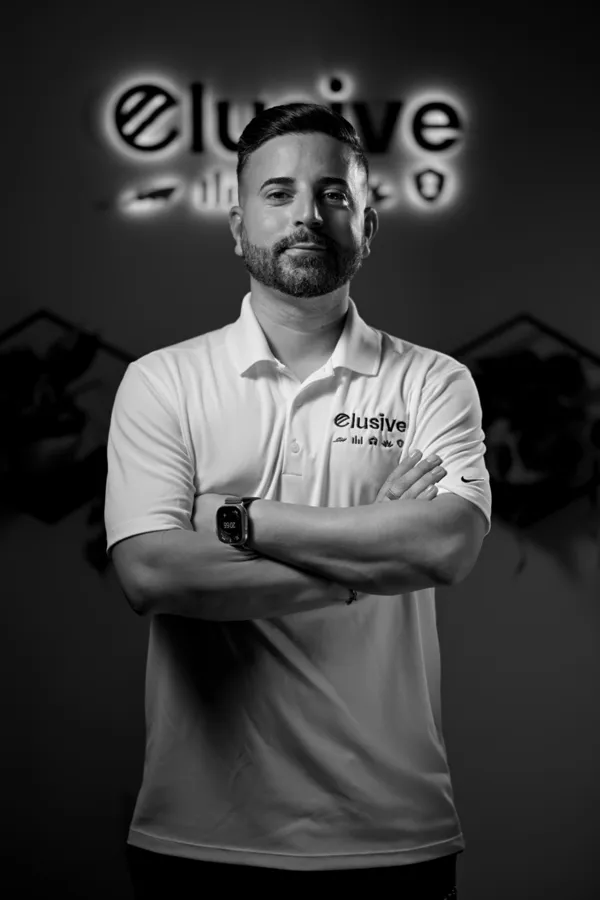 Marcel J. Reinosa in front of the Elusive Remodel sign
